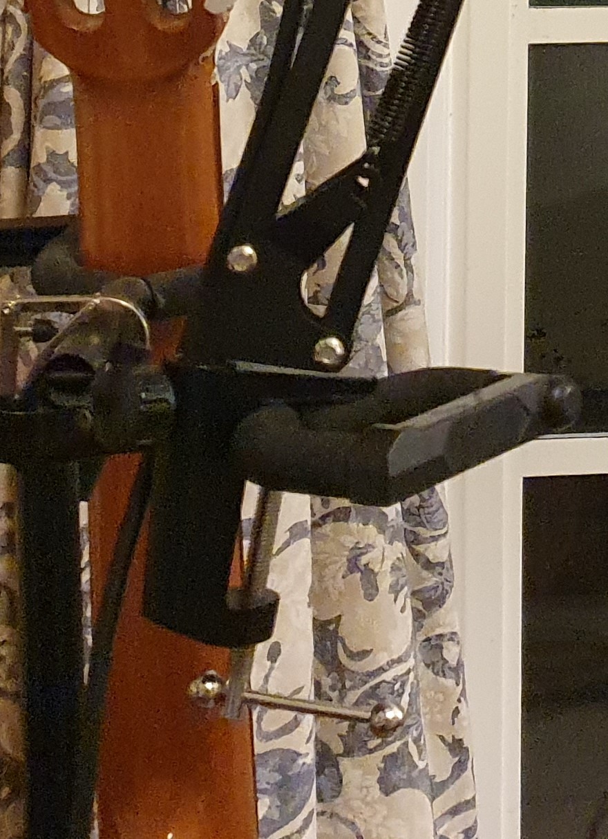 A mic stand attached unstably to a guitar stand
